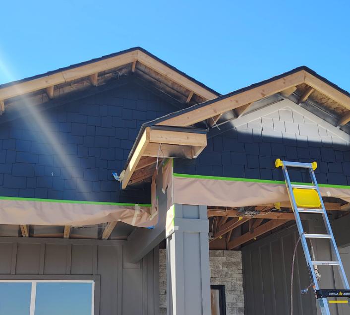 Exterior painting project with dark shingle siding and ladder on new home in Twin Falls Idaho