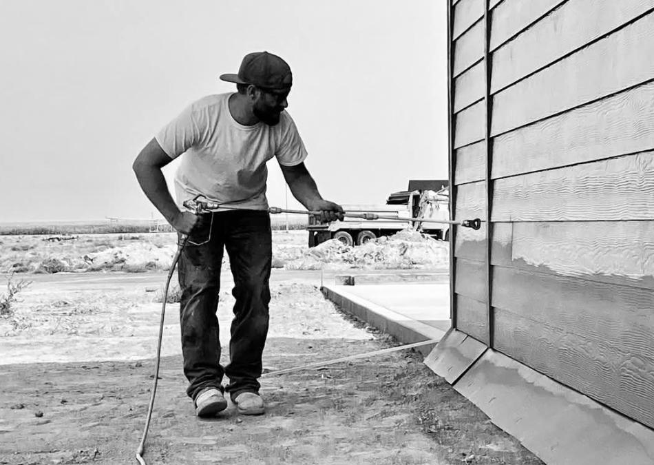 House painter spray painting exterior siding on a new home in Twin Falls Idaho